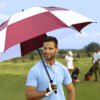 Male golfer holding Super-Sized Checkerboard Windflow Vented Golf Umbrella