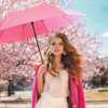 a woman holding a pink Fashion Mates Mini Folding Umbrella