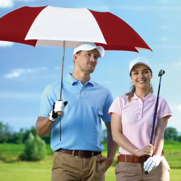 Male and female golfers standing under the umbrella