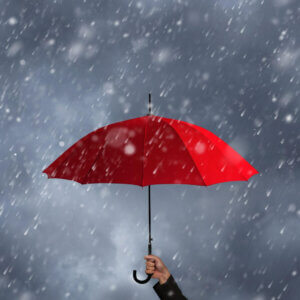 Person holding a red umbrella up to a rainy sky. 
